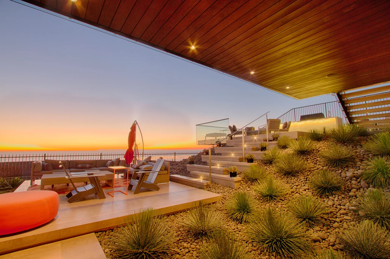 Coastal terrace with ornamental grasses and an ocean sunset
