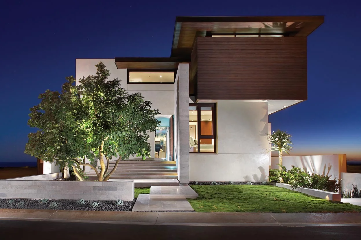 Contemporary entrance framed by olive trees and sculptural planting