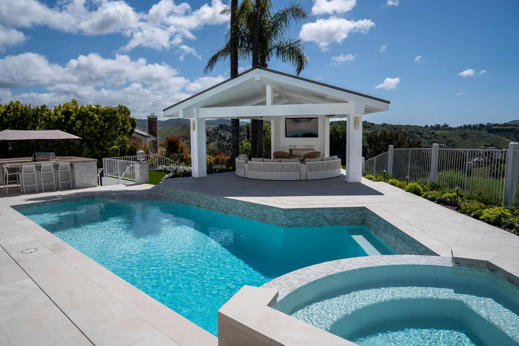 Swimming pool and spa beside a white covered outdoor lounge
