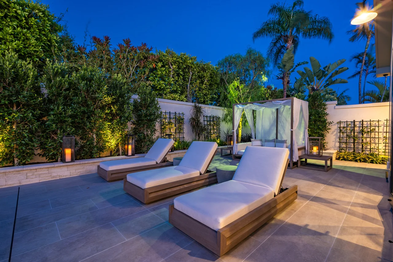Two loungers on a softly illuminated garden terrace at dusk
