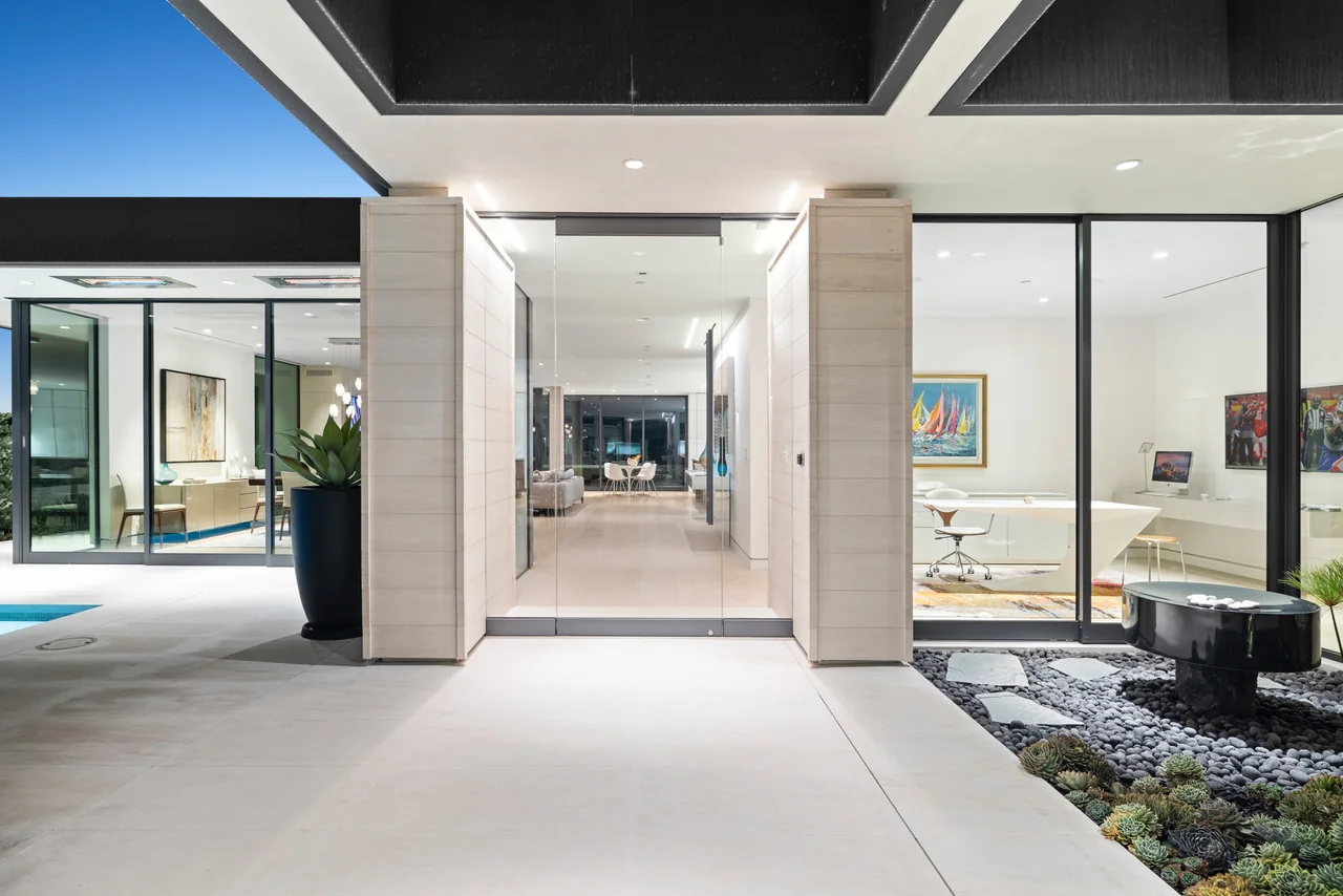 Modern covered entrance and courtyard with contrasting stone and plant details