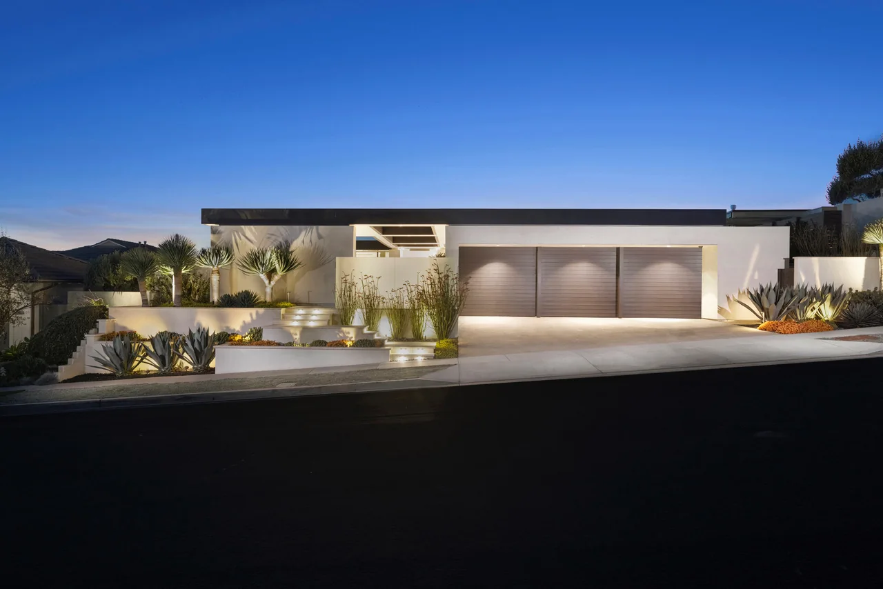 Contemporary home and landscape softly illuminated at night